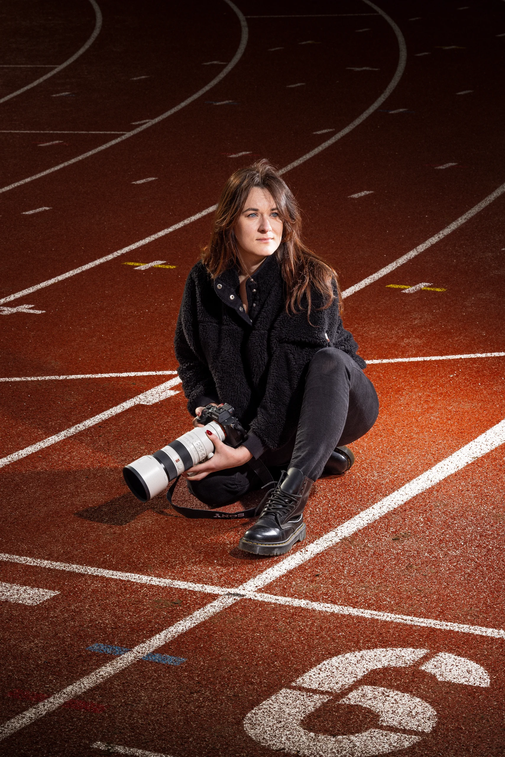 Portrait de Camille Fontaine, photographe sportive, sur une piste d’athlétisme prêt à capturer l’action