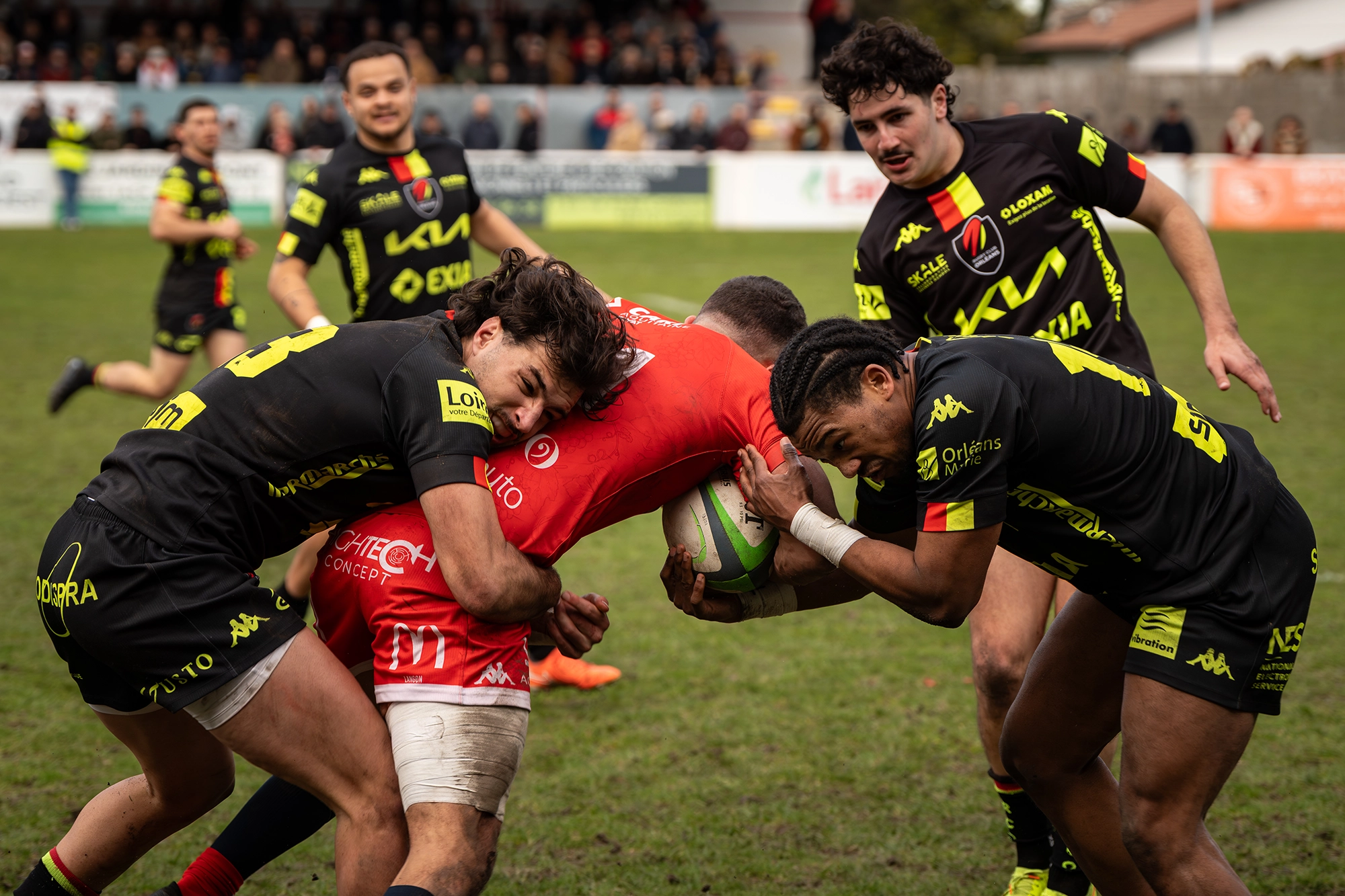 Joueur du Stade Langonnais portant le ballon et affrontant quatre joueurs d’Albi lors d’un match de rugby